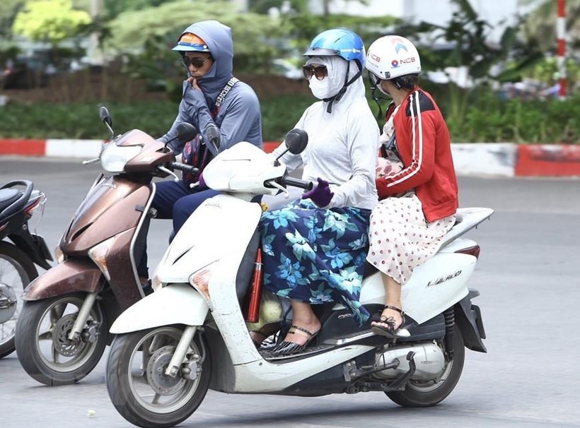 Người dân mặc áo chống nắng khi ra đường. (Ảnh: Minh Quyết/TTXVN)