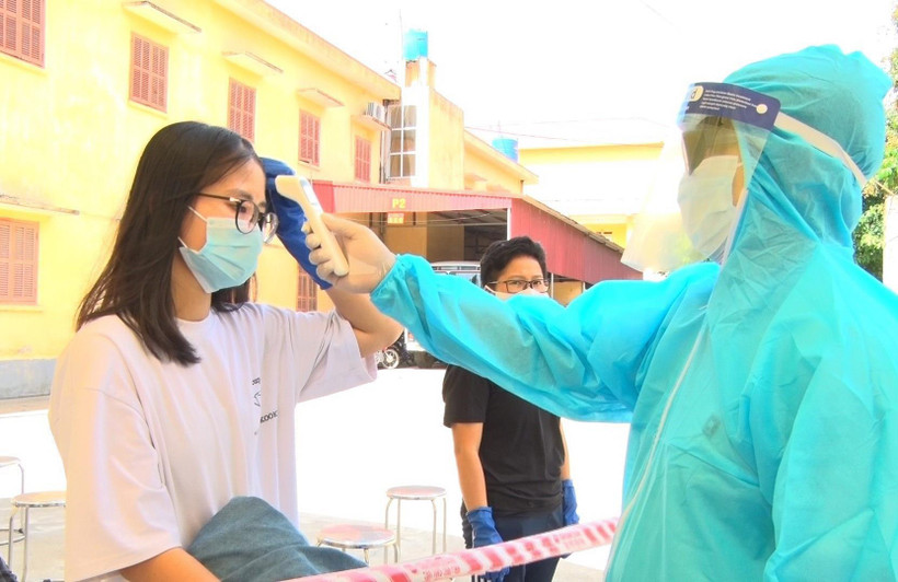 Bác sĩ kiểm tra thân nhiệt cho công dân. (Ảnh: Đinh Tuấn/TTXVN)