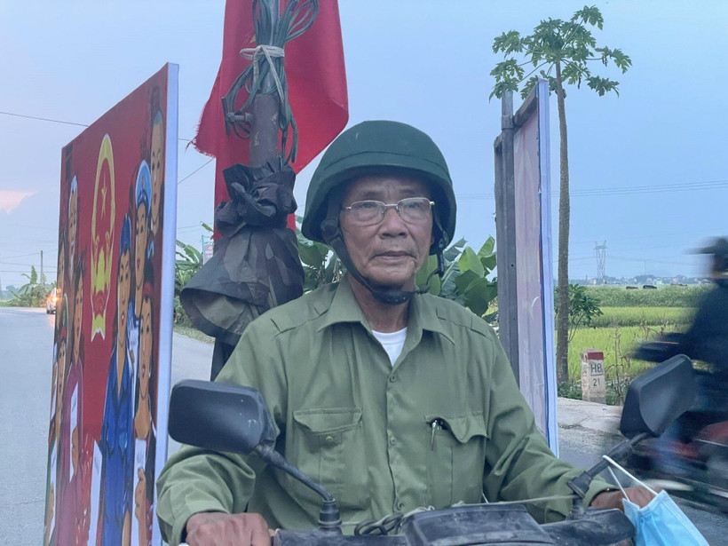 Ông Chiêng trên đường tuyên truyền các nội dung liên quan đến công tác bầu cử. (Ảnh: TTXVN phát)