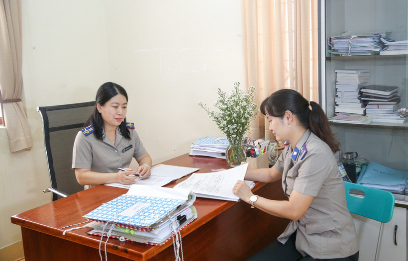 Bà Hồ Chí Bửu Nghi, Chi Cục trưởng, Chi Cục thi hành án dân sự Thị xã Hòa Thành, tỉnh Tây Ninh (bên trái) trao đổi xử lý vụ việc thi hành án khó cùng chấp hành viên. (Ảnh: Giang Phương/TTXVN) 