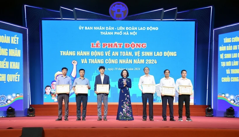 Phó Chủ tịch Ủy ban Nhân dân thành phố Hà Nội Vũ Thu Hà trao khen thưởng cho tập thể, cá nhân có thành tích trong công tác an toàn vệ sinh lao động. (Ảnh: TTXVN phát)