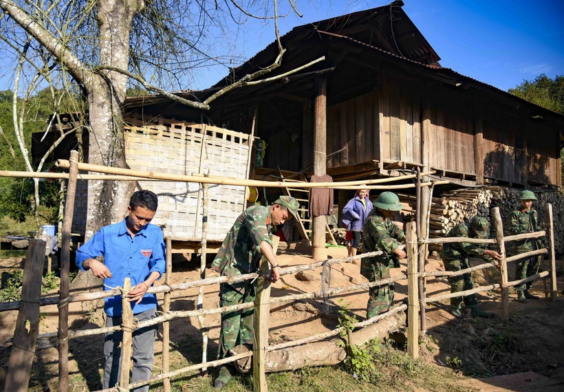 Chiến sỹ Trung đoàn 741, Bộ Chỉ huy Quân sự tỉnh Điện Biên cùng Đoàn Thanh niên xã Nậm Vì làm lại hàng rào cho người dân bản Nậm Vì. (Ảnh: Xuân Tư/TTXVN)