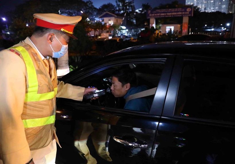 Lực lượng Cảnh sát Giao thông kiểm tra nồng độ cồn với các chủ phương tiện tham gia giao thông. (Ảnh: Phạm Kiên/TTXVN)