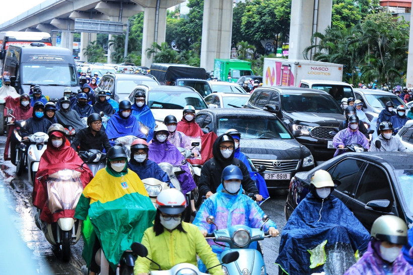 Việc di chuyển của người dân gặp khó khăn trong mưa rét. (Ảnh: Tuấn Anh/TTXVN)