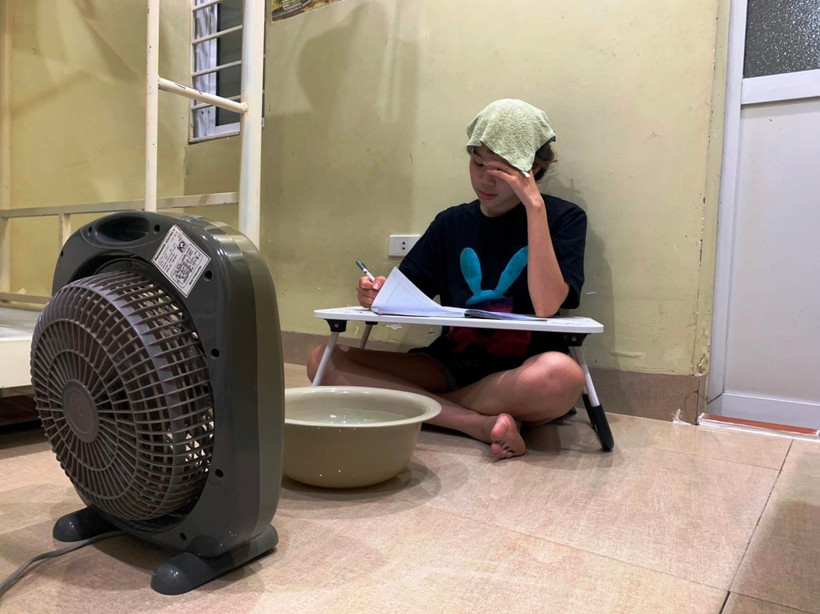 Để hạ nhiệt độ trong nhà trọ tránh nóng, sinh viên thuê phòng dùng đá lạnh bỏ vào chậu nước ngay dưới chân quạt để hơi gió phả ra đỡ nóng. (Ảnh: Bảo Anh/Vietnam+)