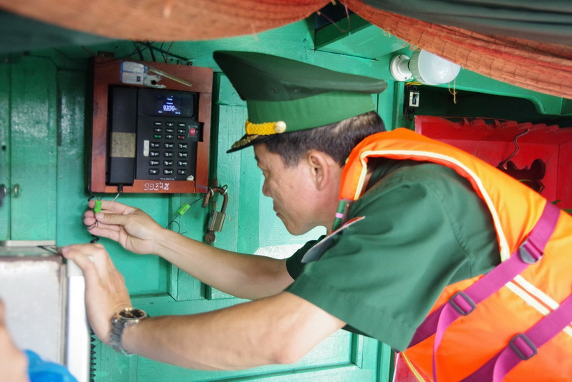 Cán bộ Đồn Biên phòng kiểm tra niêm phong, kẹp chì thiết bị giám sát hành trình trước khi tàu cá xuất bến đánh bắt hải sản trên biển. (Ảnh: Huỳnh Sơn/TTXVN)