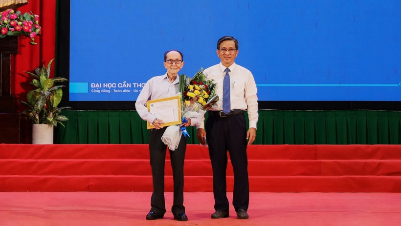 Phó Giáo sư, Tiến sỹ Trần Trung Tính, Hiệu trưởng Trường Đại học Cần Thơ trao giấy khen và học bổng toàn phần cho cụ Nguyễn Tấn Thành. (Ảnh: Ánh Tuyết/ TTXVN)