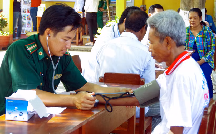 Người “thầy thuốc quân hàm xanh” Lê Văn Quốc khám bệnh cho bà con Khmer nghèo khu vực biên giới biển xã Vĩnh Hải, thị xã Vĩnh Châu, tỉnh Sóc Trăng. (Ảnh: Trung Hiếu-Văn Long/TTXVN)