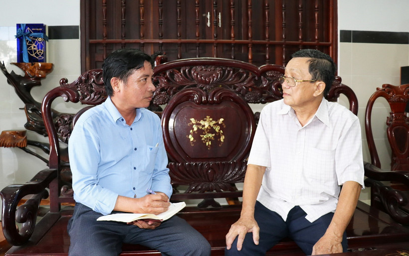 Đảng viên Đoàn Văn Thơ (bên phải), nguyên Bí thư Huyện ủy Tân Phú Đông, tỉnh Tiền Giang, hiện sinh hoạt tại chi bộ phường Long Hòa, thành phố Gò Công, tỉnh Tiền Giang trao đổi với tác giả: (Ảnh: Hữu Chí/TTXVN)