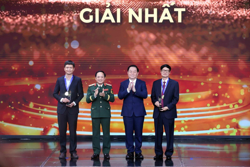 Trưởng Ban Tuyên giáo Trung ương Nguyễn Trọng Nghĩa và Chủ nhiệm Tổng cục Chính trị Quân đội nhân dân Việt Nam Trịnh Văn Quyết trao giải Nhất cho các tác giả. (Ảnh: An Đăng/TTXVN)