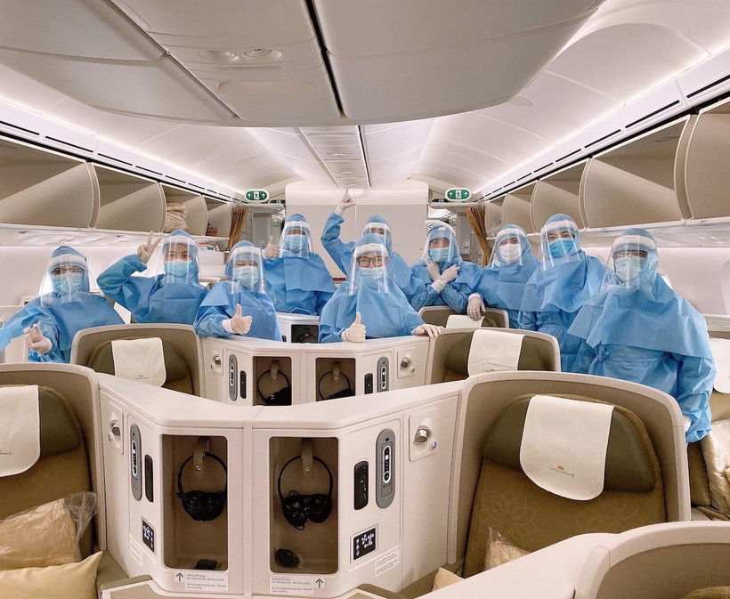 Các phi công, tiếp viên mặc trang phục bảo hộ trước khi thực hiện chuyến bay đến châu Âu. (Ảnh: VNA)