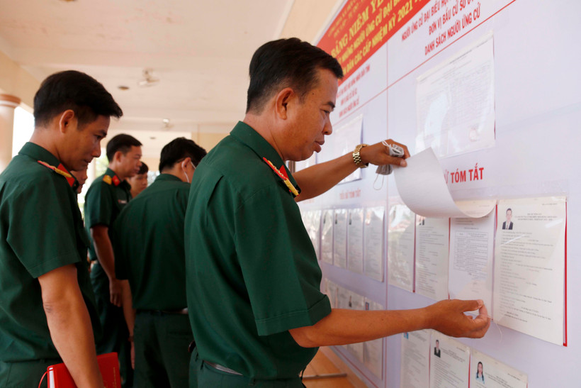 Các chiến sỹ thuộc Bộ Chỉ huy Quân sự tỉnh Cà Mau theo dõi danh sách cử tri được niêm yết tại đơn vị. (Ảnh: Kim Há/TTXVN)