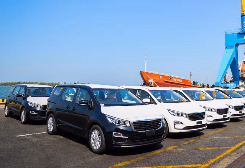 Lô xe Kia Grand Carnival được đưa vào container tại Khu công nghiệp THACO Chu Lai (Quảng Nam) để xuất khẩu sang Thái Lan. (Nguồn: PV/Vietnam+)