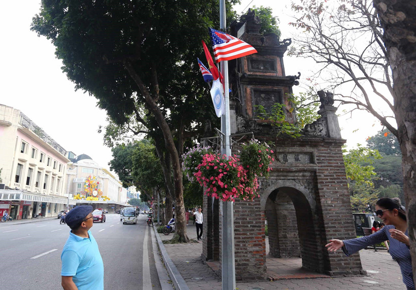 Cờ Mỹ, cờ Triều Tiên và cờ Việt Nam, bên dưới là biểu tượng hai bàn tay bắt chặt vào nhau thể hiện tinh thần của cuộc gặp lớn, được treo quanh hồ Hoàn Kiếm. (Ảnh: Danh Lam/TTXVN)