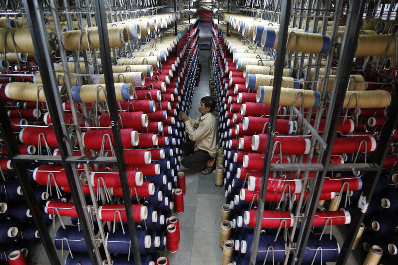 Công nhân kiểm tra các ống sợi trên máy dệt thảm tại một nhà máy ở ngoại ô Jammu, Ấn Độ. (Ảnh: AFP/TTXVN)