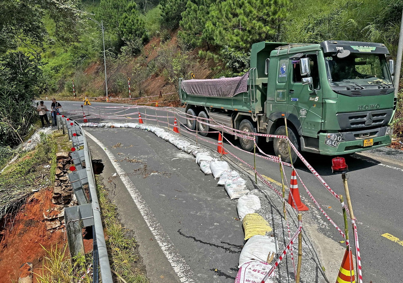Cơ quan chức năng đã triển khai các biện pháp đảm bảo an toàn giao thông tại khu vực bị sạt lở và bố trí nhân sự trực điều tiết giao thông trên đèo Tà Nung. (Ảnh: Nguyễn Dũng/TTXVN)