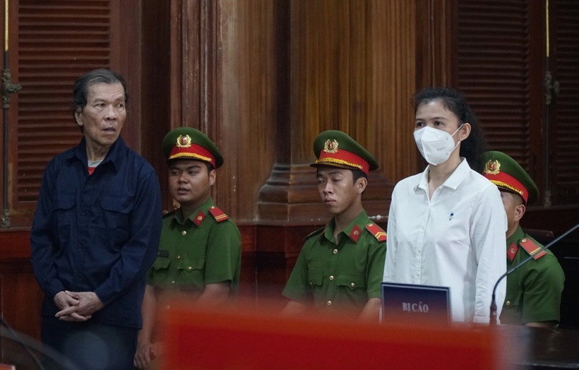 Hai bị cáo Trần Văn Sỹ (trái) và bị cáo Đặng Thị Hàn Ni (phải) đứng nghe tuyên án. (Ảnh: Hồng Giang/TTXVN)