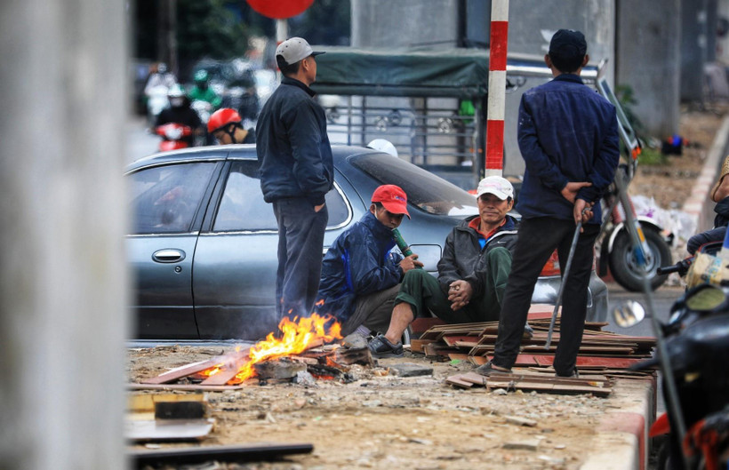 Người lao động đốt củi sưởi ấm khi nhiệt độ xuống thấp. (Ảnh: Thành Đạt/TTXVN)