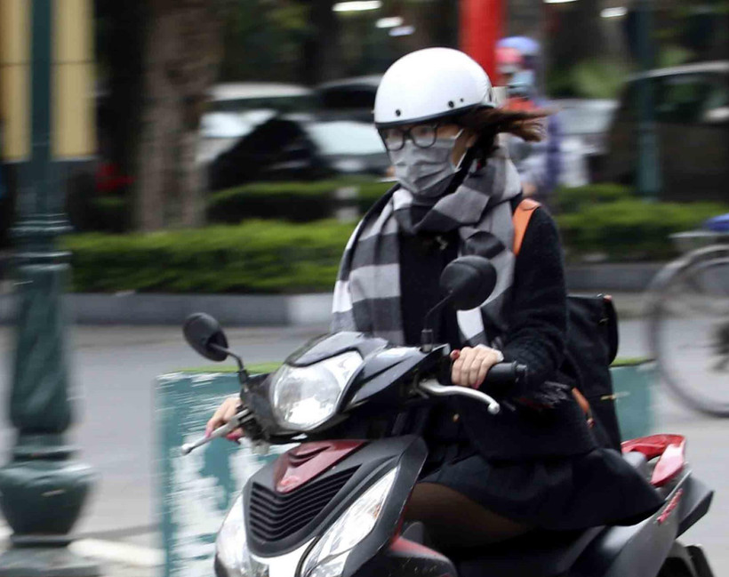 Giữ ấm cơ thể với nhiều lớp áo, khăn quàng và đeo khẩu trang khi ra đường khi trời rét đậm, rét hại. (Ảnh: Tuấn Đức/TTXVN)