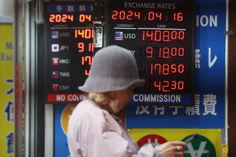 Một người dân đi ngang qua văn phòng đổi tiền ở Myeong-dong, Seoul, ngày 16/4. (Nguồn: Yonhap)