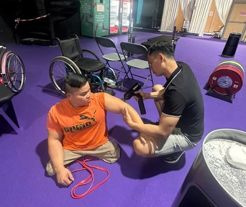 Bác sỹ Nguyễn Việt Tuấn (áo đen) chăm sóc cho lực sỹ Nguyễn Bình An. (Ảnh: TTXVN phát)