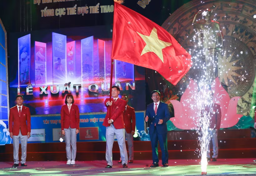 Ông Trần Đức Phấn, Phó Tổng cục trưởng Tổng cục Thể dục thể thao, Trưởng Đoàn thể thao Việt Nam tham dự SEA Games 30 phất cao lá quốc kỳ Việt Nam trong Lễ xuất quân. (Ảnh: Trọng Đạt/TTXVN)