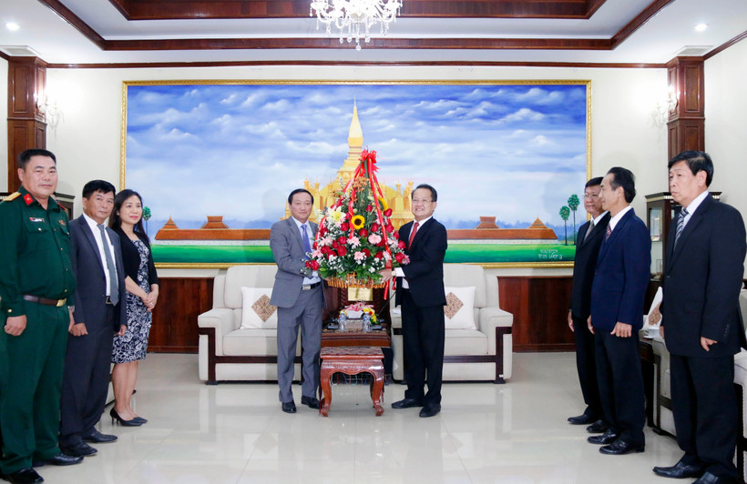 Đại sứ Việt Nam tại Lào Nguyễn Bá Hùng trao lẵnh hoa chúc mừng 66 năm Ngày thành lập Đảng NDCM Lào. (Ảnh: Phạm Kiên/TTXVN)