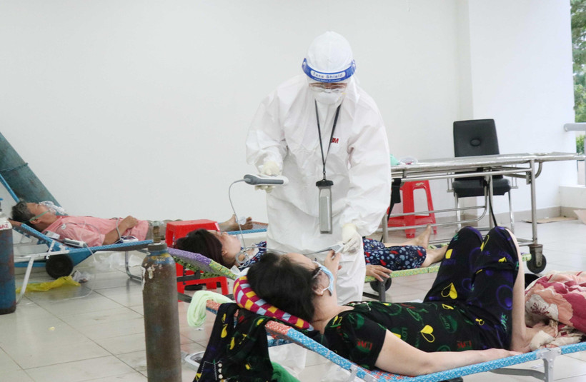 Các bác sỹ thăm khám bệnh nhân nhiễm COVID-19 không triệu chứng có bệnh nền tại Bệnh viện dã chiến thu dung điều trị COVID-19 số 3, thành phố Thủ Đức. (Ảnh: Xuân Khu-TTXVN)