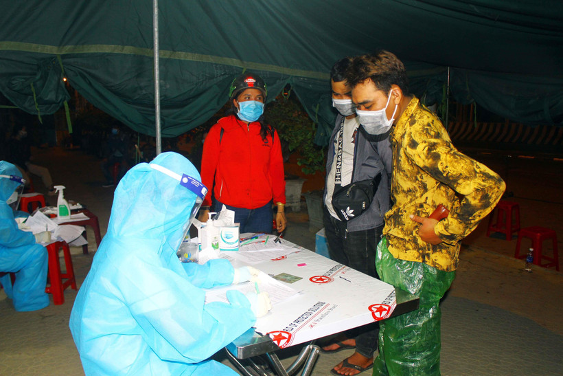 Công dân Nghệ An trở về từ các tỉnh phía Nam bằng xe máy khai báo thông tin y tế tại chốt kiểm soát cầu Bến Thủy 1. (Ảnh: Tá Chuyên/TTXVN)