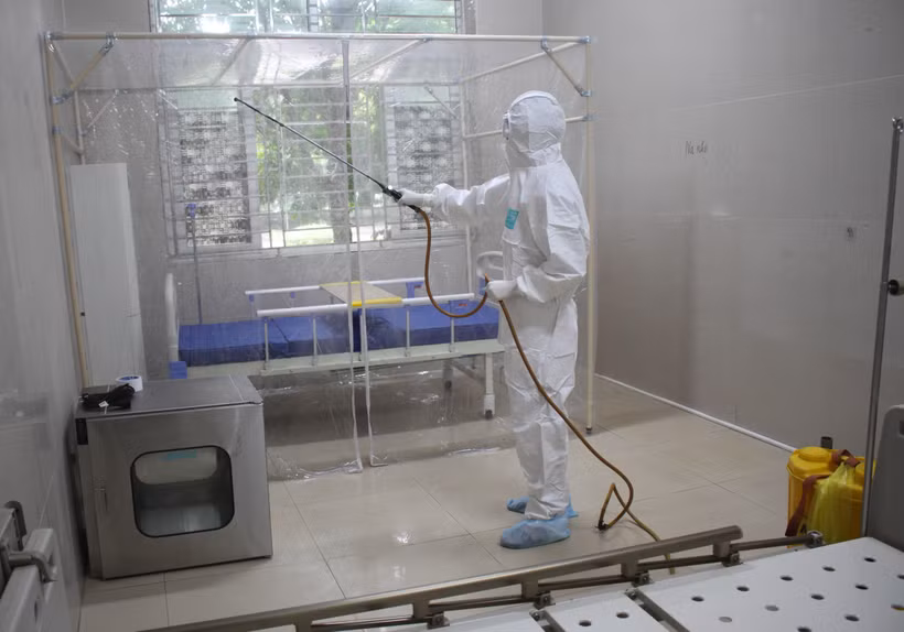 Nhân viên y tế Khu cách ly đặc biệt phun thuốc khử trùng. (Ảnh: Thùy Dung/TTXVN)