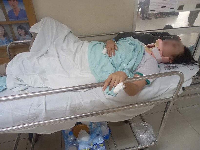 Em N. bị gãy đốt sống cổ số 2, bị thương ở tay, phải nằm cố định một chỗ để điều trị, mọi sinh hoạt cá nhân đều do người nhà chăm lo. (Ảnh: TTXVN phát)