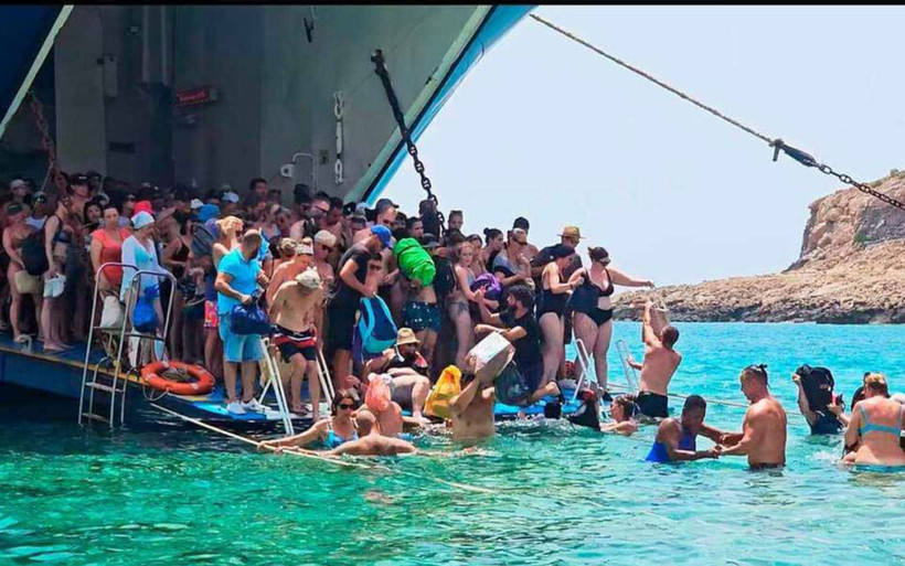 Du khách phải lội nước vào đảo. (Nguồn: ekathimerini.com)