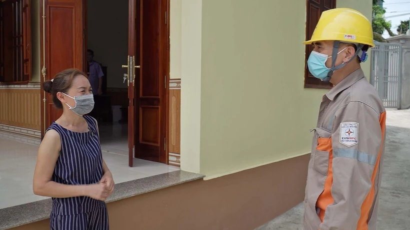 Cán bộ Điện lực huyện Kim Bôi giải thích cho người dân ngành điện không bán loại bảo hiểm tai nạn hộ dùng điện. (Ảnh: Thanh Hải/TTXVN)