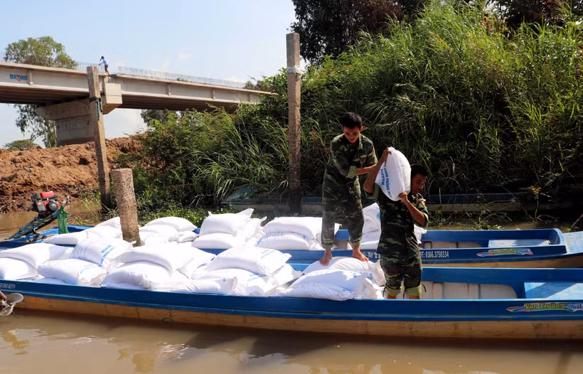 Cán bộ, chiến sỹ Đồn Biên phòng Vĩnh Nguơn (Bộ đội Biên phòng tỉnh An Giang) bốc dỡ số đường cát nhập lậu vào kho tạm giữ. (Ảnh: Công Mạo/TTXVN)