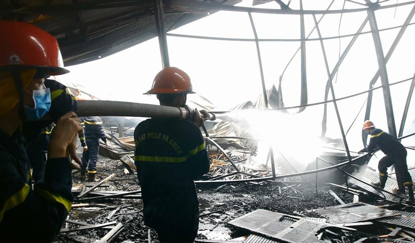 Các chiến sỹ cảnh sát Phòng cháy chữa cháy đang tích cực dập tắt khu vực còn cháy âm ỉ bên trong. (Ảnh: Quốc Dũng/- TTXVN)