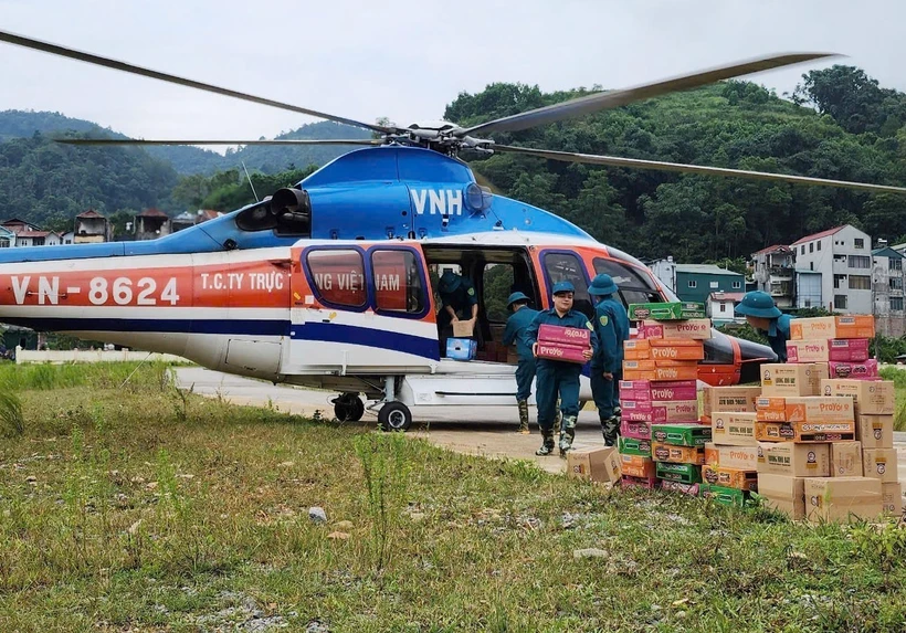 Chuyển hàng cứu trợ từ trực thăng xuống vùng lũ thuộc huyện Nguyên Bình. (Ảnh: Thông tấn Quân sự/TTXVN phát)