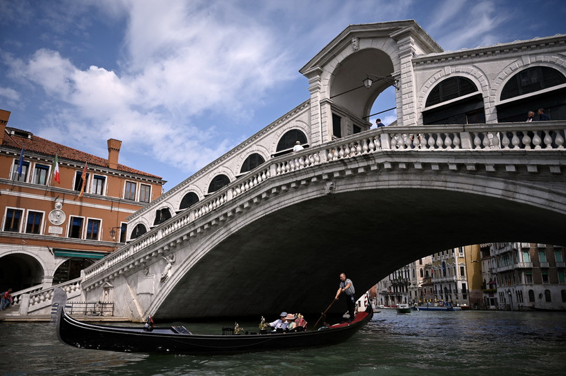 Khách du lịch đi thuyền gondola tại Venice, Italy. (Ảnh: AFP/TTXVN)