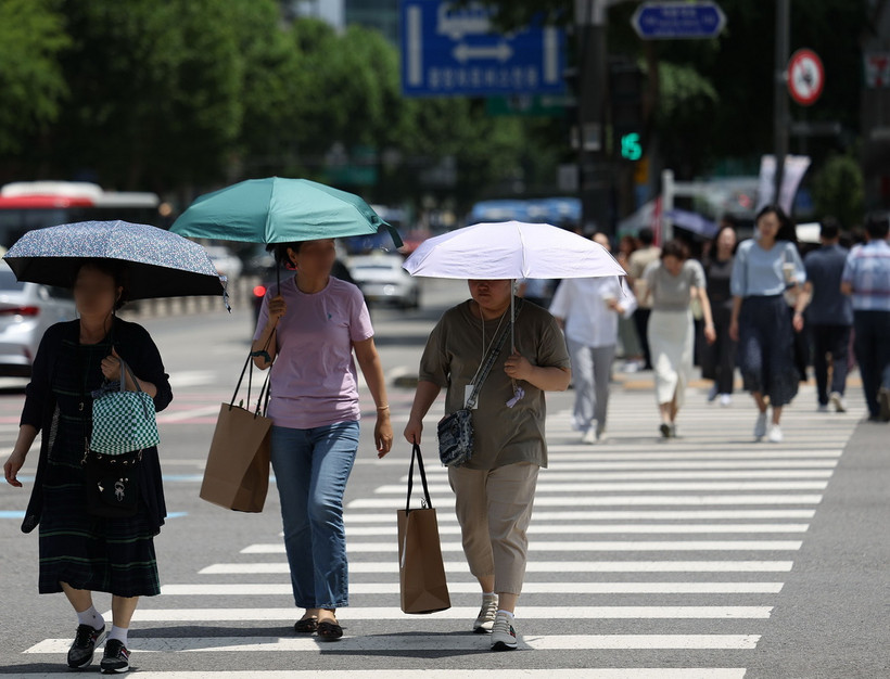 Người dân xếp hàng nhận cơm từ thiện dưới trời nắng nóng tại Seoul, Hàn Quốc ngày 1/8/2023. (Ảnh: Yonhap/TTXVN)