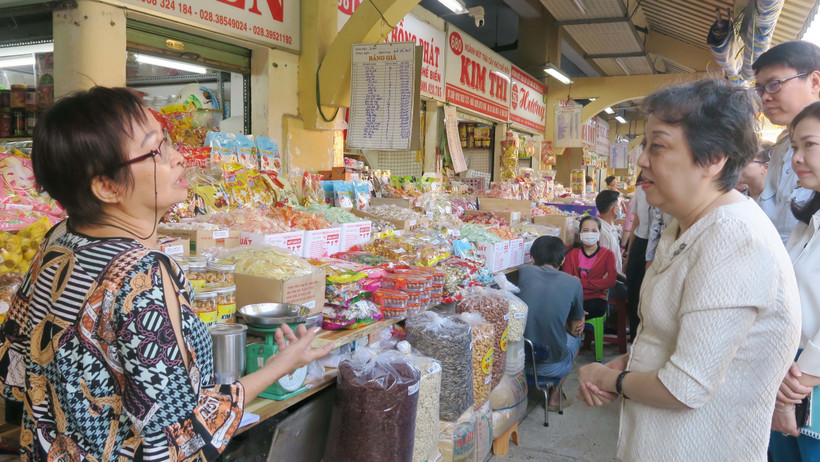 Lãnh đạo Sở An toàn thực phẩm Thành phố Hồ Chí Minh trao đổi với tiểu thương chợ Bình Tây về công tác đảm bảo an toàn thực phẩm. (Ảnh: Đinh Hằng/TTXVN)