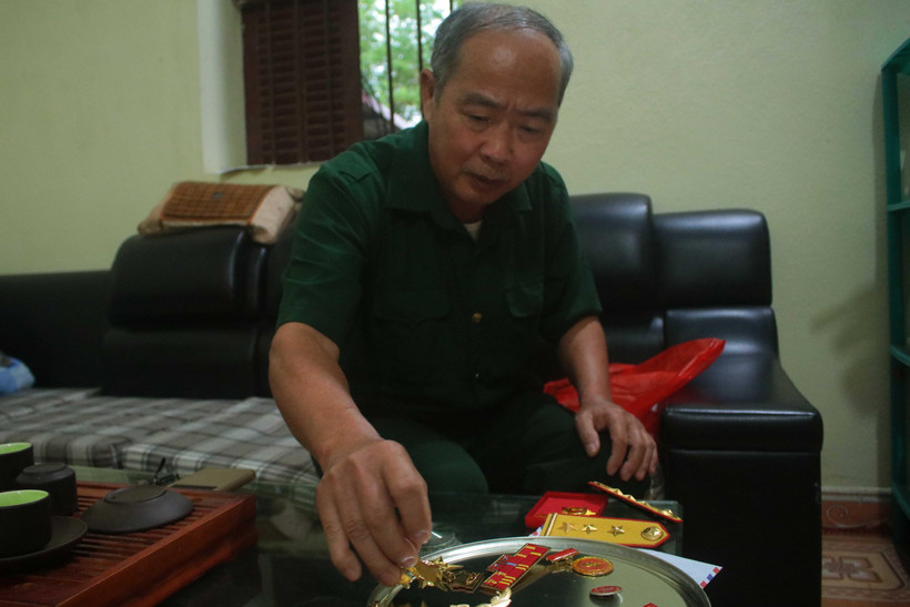  Cựu chiến binh Trần Đức Hòa bên những kỷ vật từ thời kháng chiến chống Mỹ cứu nước. (Ảnh: Chu Hiệu/TTXVN)