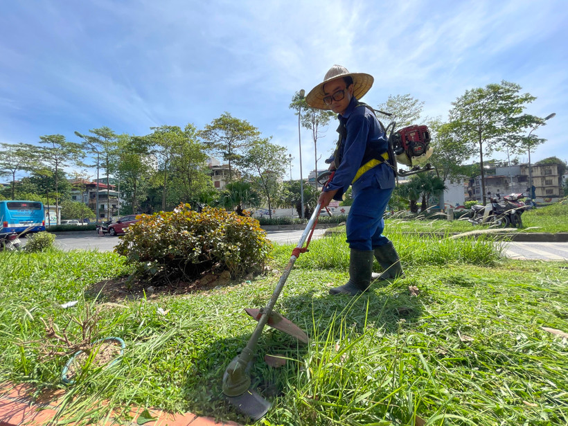 Nhân viên cây xanh Hà Nội đang căng mình làm việc dưới tiết trời gần 40 độ C (ảnh chụp sáng ngày 21/6/2021). (Ảnh: Minh Hiếu/Vietnam+)