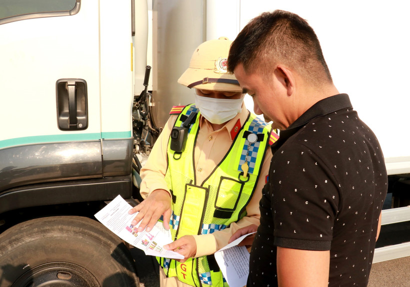 Cảnh sát giao thông tuyên truyền cho lái xe đi vào cao tốc Cam Lộ-La Sơn được an toàn tại điểm đầu ở xã Cam Hiếu, huyện Cam Lộ (Quảng Trị). (Ảnh: Nguyên Lý/TTXVN)