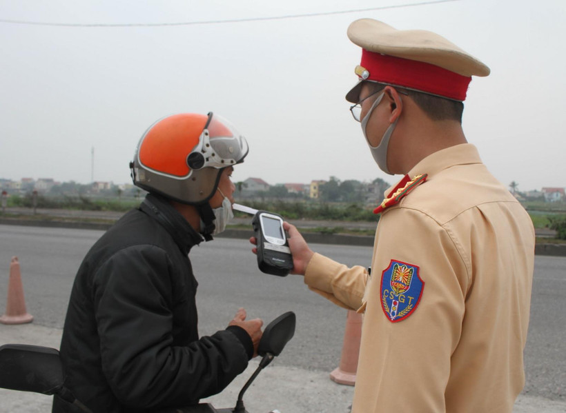 Cảnh sát giao thông kiểm tra nồng độ cồn của người điều khiển phương tiện. (Ảnh: Thùy Dung/TTXVN)