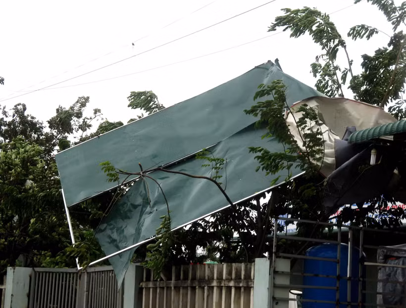 Nhiều mái tôn tại nhà dân bị gió cuốn phăng. (Ảnh: Lê Ngọc Phước/TTXVN)