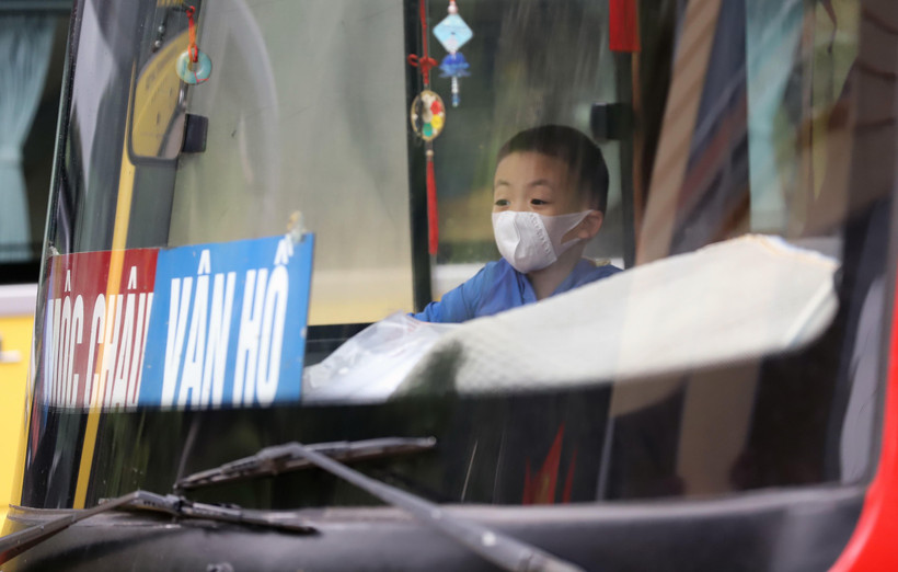 Một em bé trên tuyến Sơn La-Mộc Châu-Vân Hồ được bố, mẹ đeo khẩu trang để đảm bảo phòng, chống dịch COVID-19. (Ảnh: Quang Quyết/TTXVN)