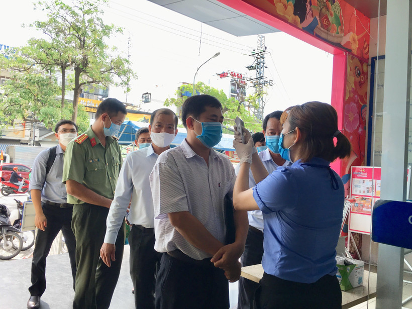 Hệ thống siêu thị thực hiện việc đo thân nhiệt cho khách hàng. (Ảnh: Thanh Vân-TTXVN)