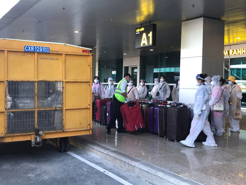 Công dân Việt Nam từ nước ngoài trở về chuẩn bị rời sân bay Cam Ranh đến khu cách ly tập trung. (Ảnh: Phan Sáu/TTXVN)