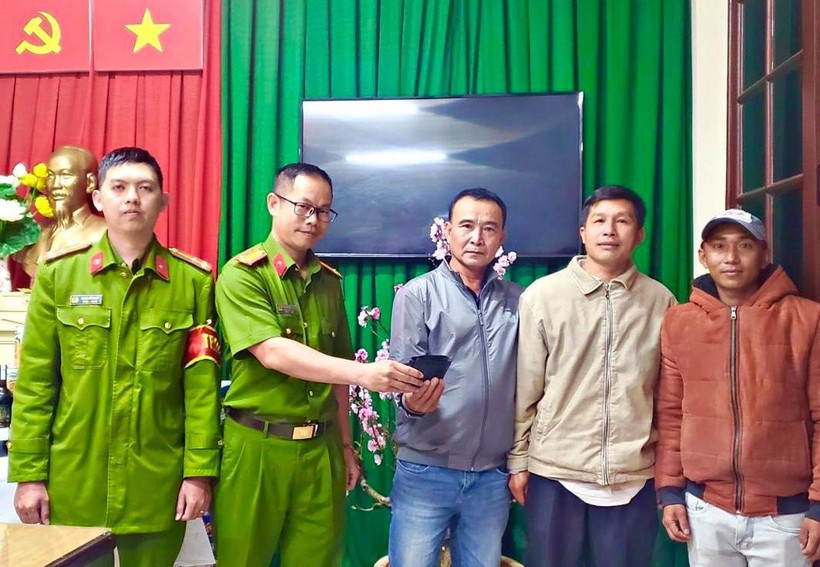 Công an phường 3 trả lại chiếc ví cho du khách ông Nguyễn Lê Trãi, 52 tuổi, trú tại huyện Diên Khánh, tỉnh Khánh Hòa trước sự chứng kiến của anh Thương và ông Khánh. (Ảnh: TTXVN phát)