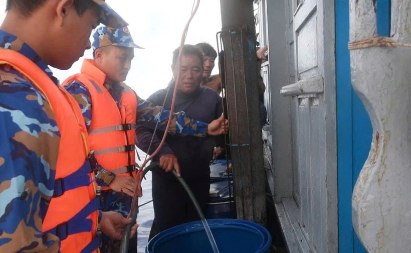 Chiến sỹ tàu 471 tiến hành cung cấp nước ngọt cho tàu QNg 96615 TS của ngư dân Quảng Ngãi. (Ảnh: TTXVN phát)