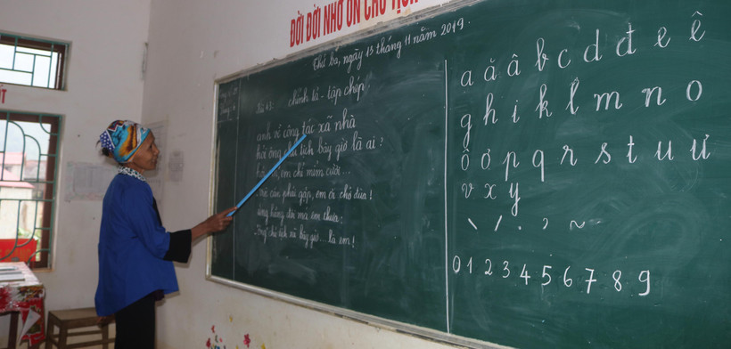 Đến lớp xóa mù chữ, người dân được luyện đọc những bài thơ ngắn. (Ảnh: Chu Hiệu/TTXVN)